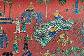 Wat Xieng Thong temple in Luang Prabang, Laos.  La Chapelle Rouge , the Red Chapel. The exterior walls are decorated with colourful mosaics on a pink background with scenes of people daily activities. South wall.